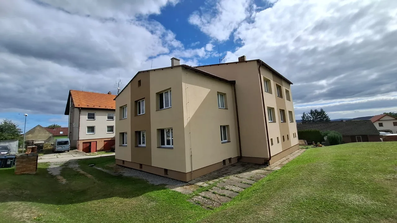 Bytový dům v Ločenicích po rekonstrukci, zadní roh s novou fasádou a hnědým soklem