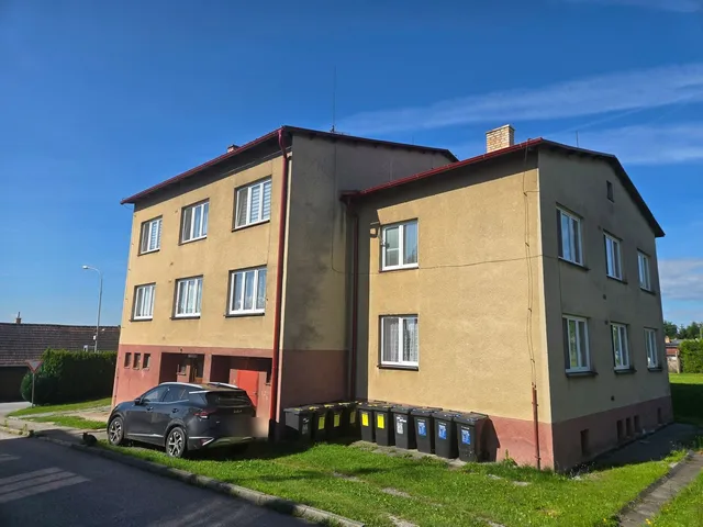 Uliční strana bytového domu v Ločenicích před rekonstrukcí, oprýskaná fasáda a sokl