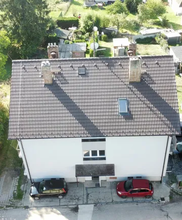 Nová střecha z hnědých betonových tašek na bytovém domě v Otěvěku, pohled dronem shora