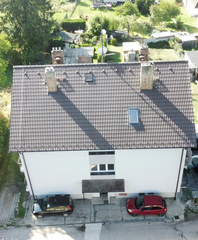Nová střecha z hnědých betonových tašek na bytovém domě v Otěvěku, pohled dronem shora