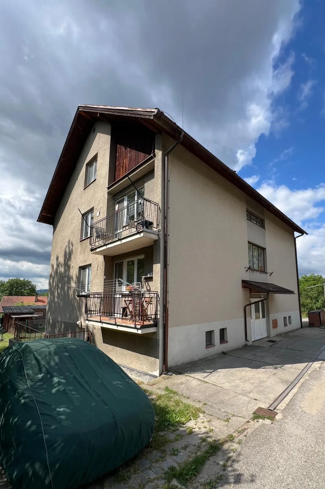 Bytový dům v Otěvěku před rekonstrukcí, roh s balkony a původní béžovou fasádou