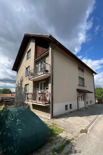 Bytový dům v Otěvěku před rekonstrukcí, roh s balkony a původní béžovou fasádou