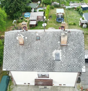 Původní střecha bytového domu v Otěvěku z dronu, zvětralá krytina s lišejníkem a vyspravenými místy