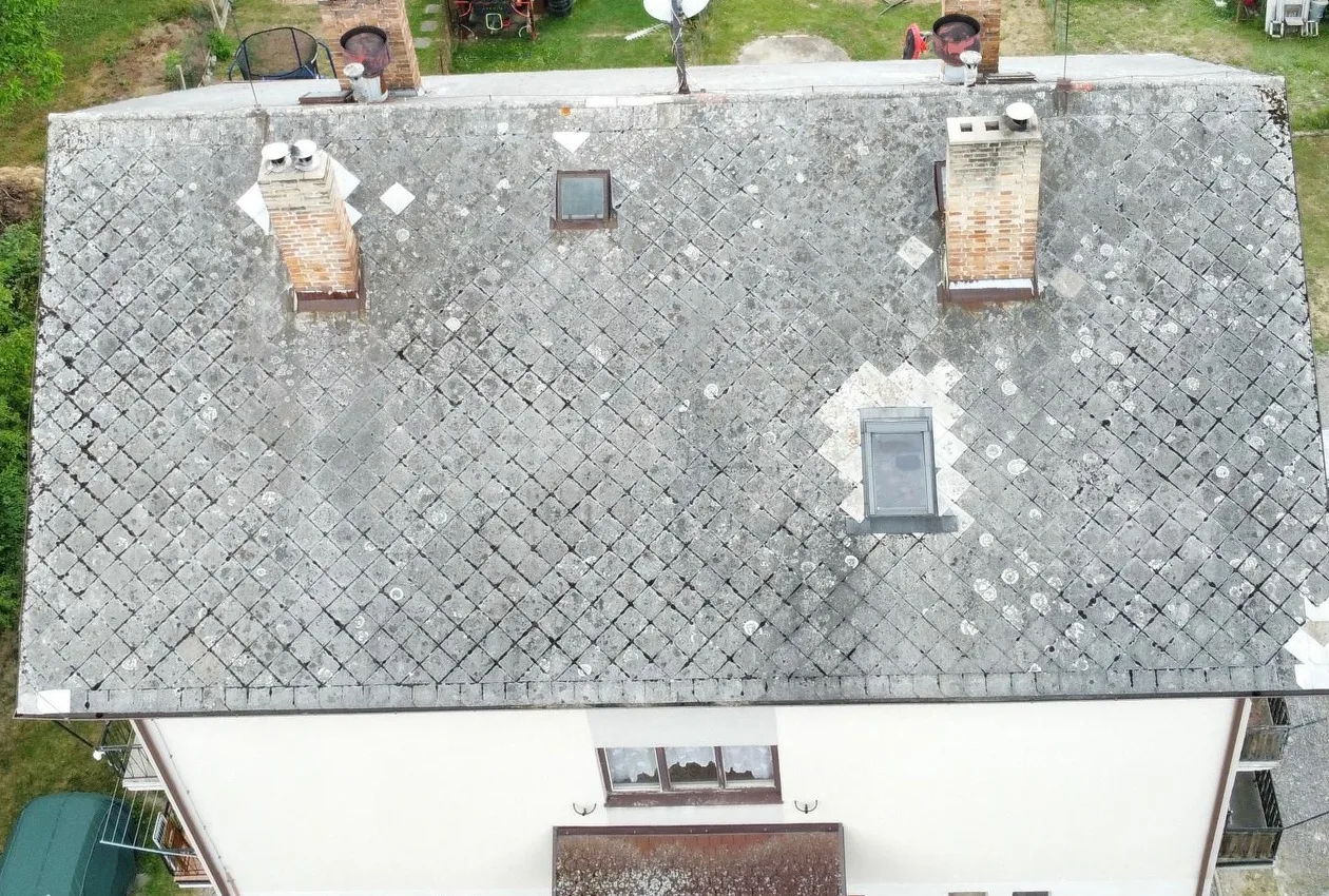 Původní střecha bytového domu v Otěvěku z dronu, zvětralá krytina s lišejníkem a vyspravenými místy