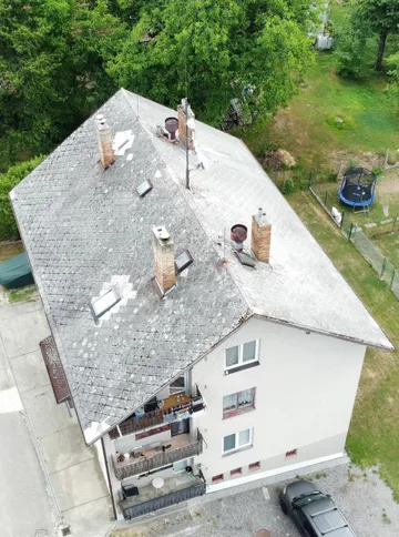 Bytový dům v Otěvěku z dronu před rekonstrukcí, původní střecha nad balkonovou stranou