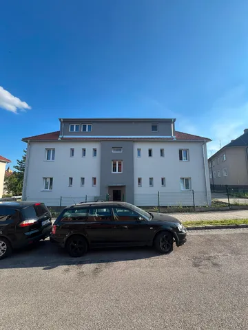 Čelní pohled na bytový dům ve Zlivi s novou fasádou
