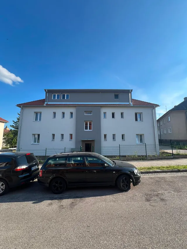 Čelní pohled na bytový dům ve Zlivi s novou fasádou