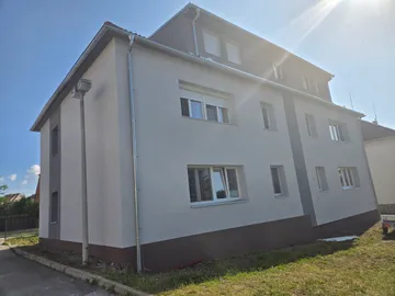 Zadní část bytového domu ve Zlivi s dokončenou fasádou a novými parapety