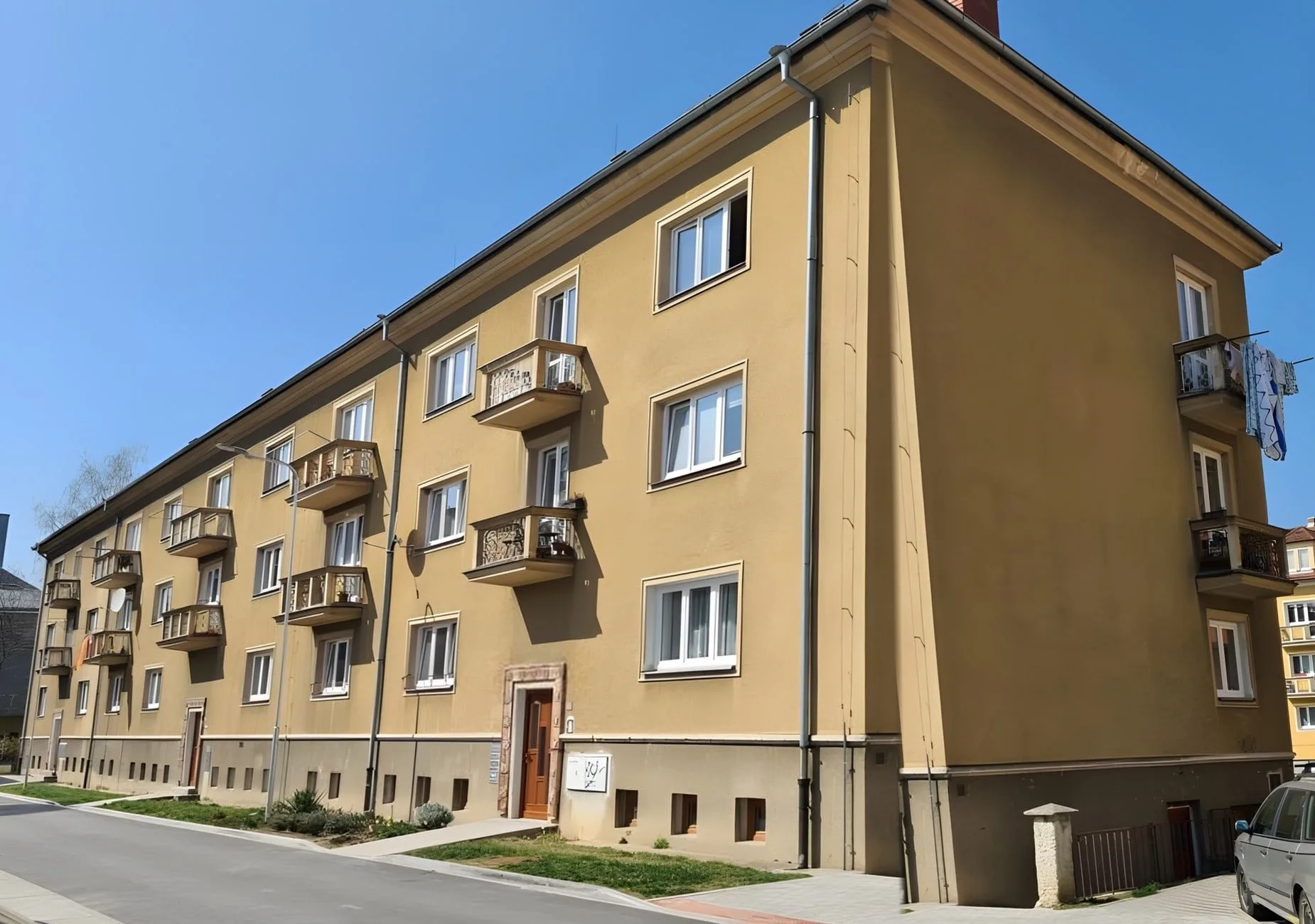 Uliční strana bytového domu na Libuši v Bechyni před rekonstrukcí, původní žlutá fasáda